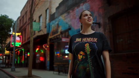 young woman in jimi hendrix t-shirt on a vibrant city street