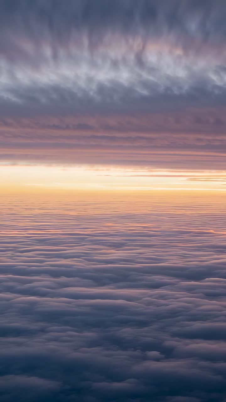 Vertical video: Recording high-altitude cloud layer drifting above horizon at dawn with pastel sky