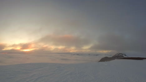 time lapse during midnight sun with moving clouds on the mountain peak in northern scandinavia