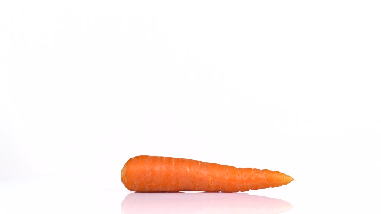 un bucle sin fin de una zanahoria fresca girando sobre un fondo blanco. vista lateral.