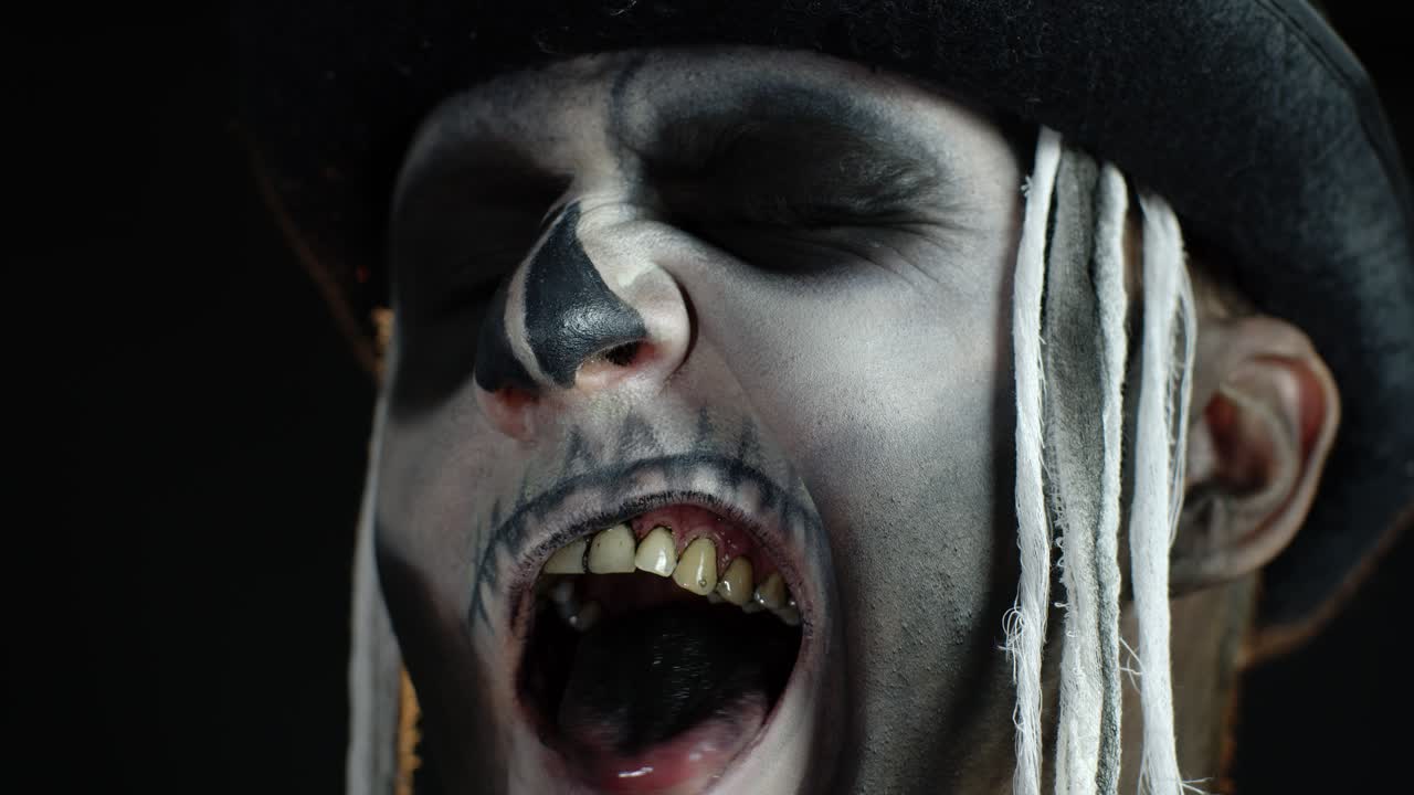 imágenes de cerca de un hombre siniestro con maquillaje de esqueleto de halloween haciendo caras, tratando de asustar