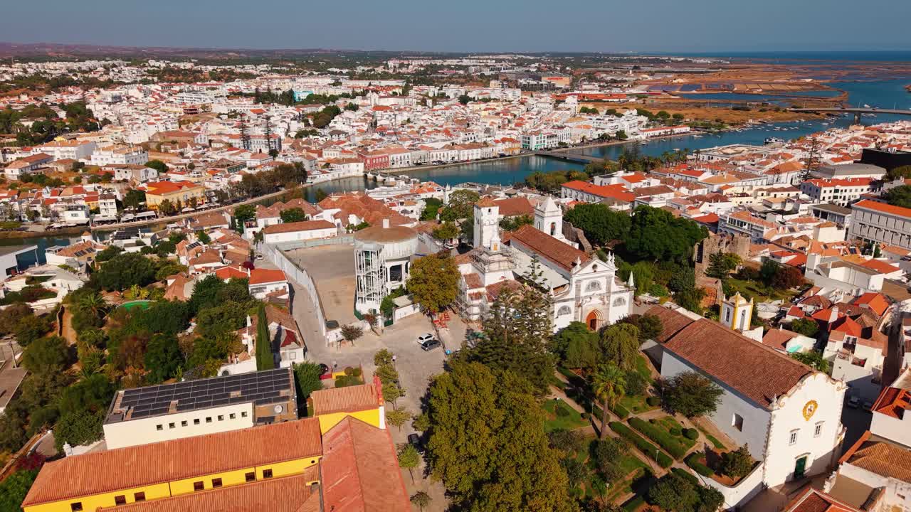 Aerial shot over the historic town of Tavira with the castle, st Mary's church and the roman bridge over the Gilao river on a sunny day, Algarve region, Portugal
