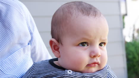 grandmother sitting outside house playing with baby grandson