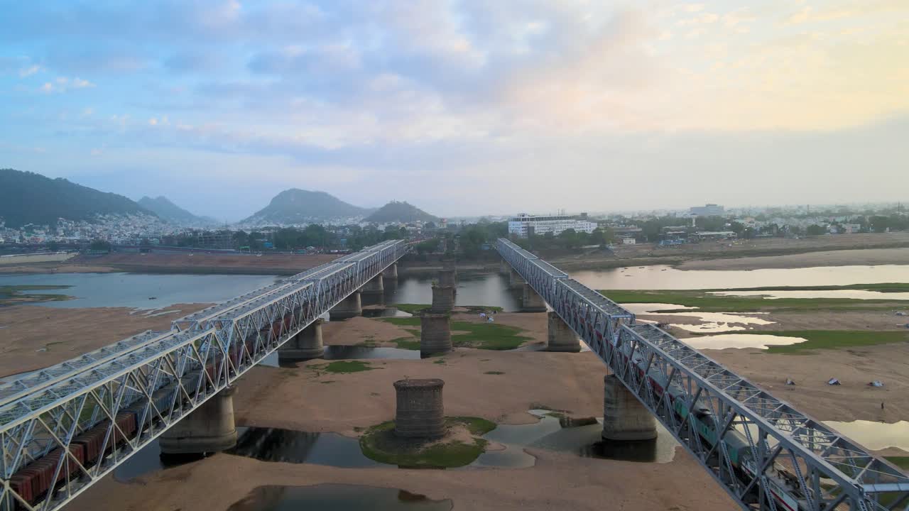 una toma aérea de vijayawada en las tranquilas primeras horas, con la luz del sol atravesando las nubes de la mañana para revelar la ciudad.