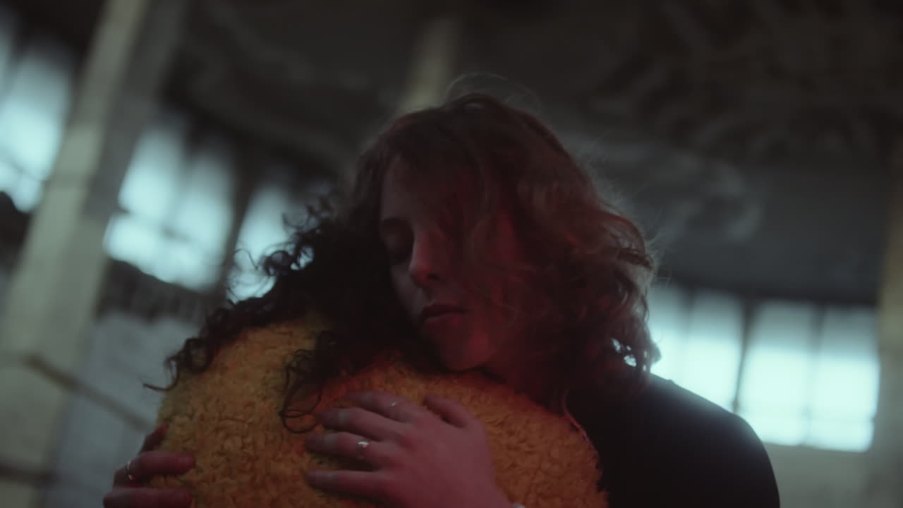 Two people sharing a comforting embrace in a dimly lit, atmospheric interior