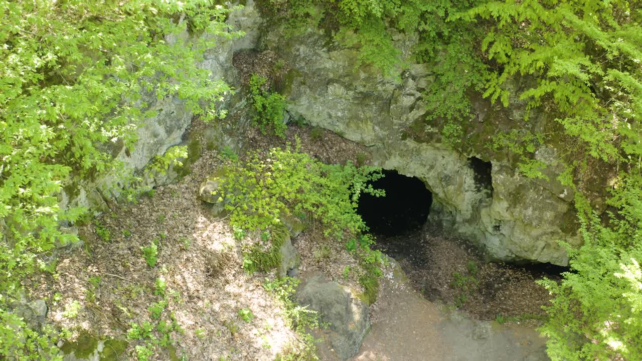 un pedestal disparado por un dron se mueve por encima de la abertura de una cueva conocida como el sitio de la tumba de la diosa egipcia bastet, ubicada en las montañas de strandzha en bulgaria.