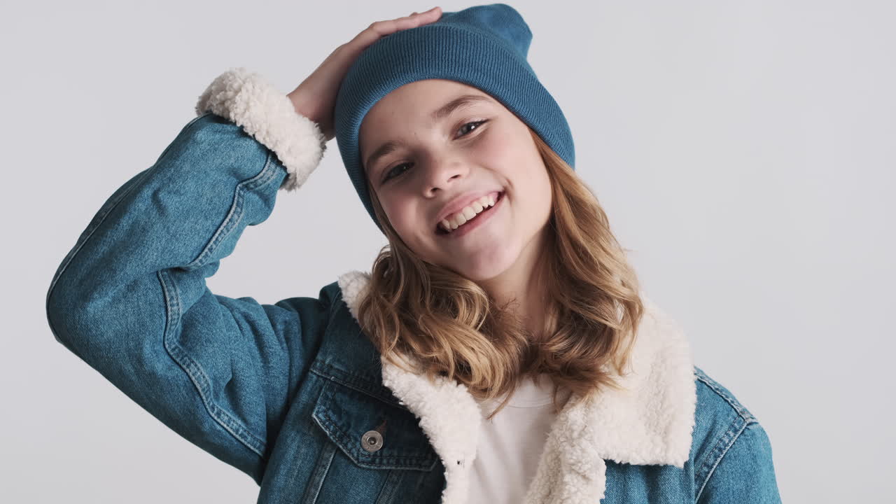 подростковая белая девушка в джинсовой куртке и кивает головой.