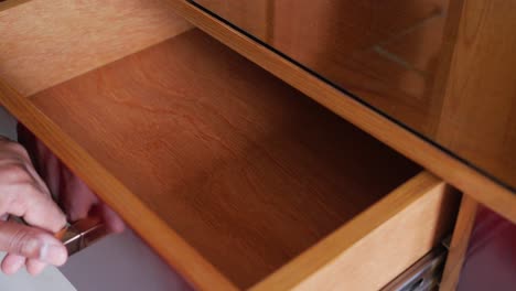 a person opens a drawer in a wooden cabinet