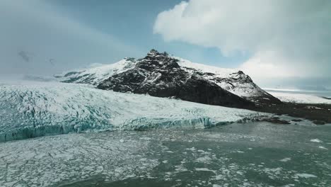 Floating-Ice-from-Glaciers-in-Beautiful-Mountainous-Iceland-Landscape,-Aerial