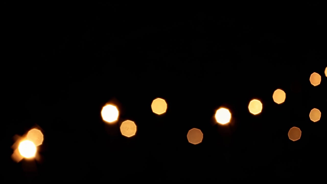Golden Octagon Bokeh Lights Twinkling on Black Background