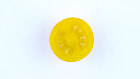 top view from above of a yellow tomato. cross section. rotating on the turntable isolated on the white background. close-up. macro.