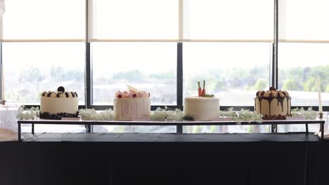 Four-different-cakes-on-indoor-wedding-reception-feast-banquet-table