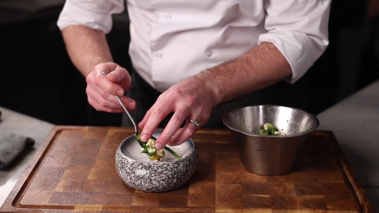 Chef che impiattava un'insalata di verdure fresche in una cucina professionale