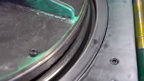 close shot of secured on a rotary table, drum lids undergo a precise, automated machining process