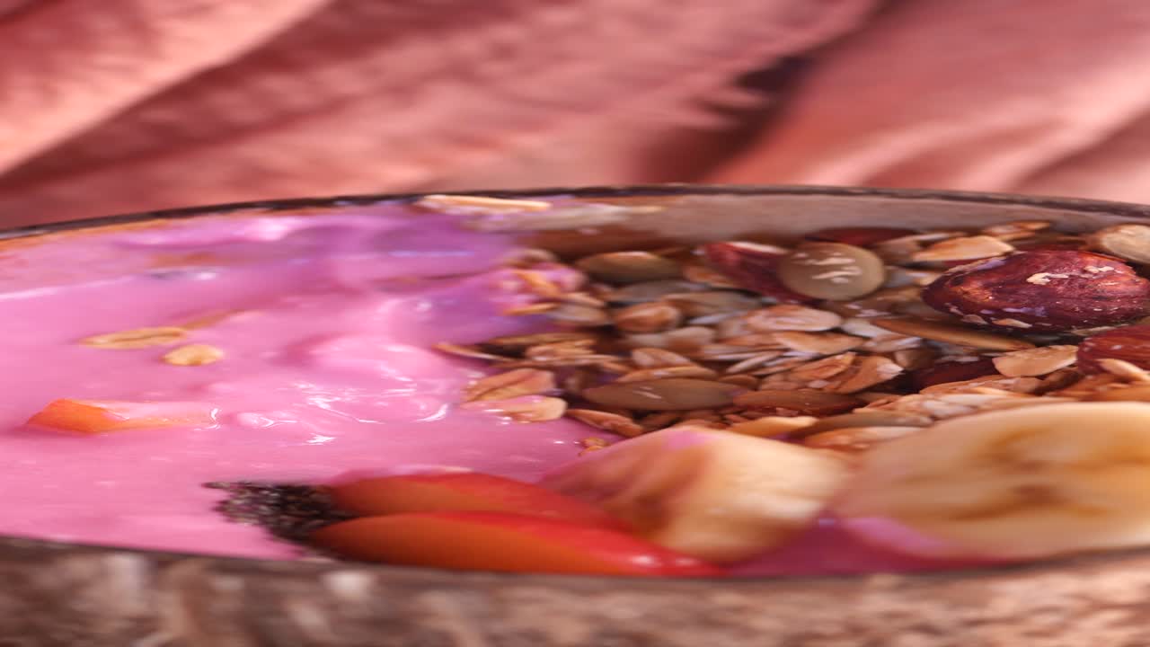 un tazón de batido saludable con plátano, granola y bayas