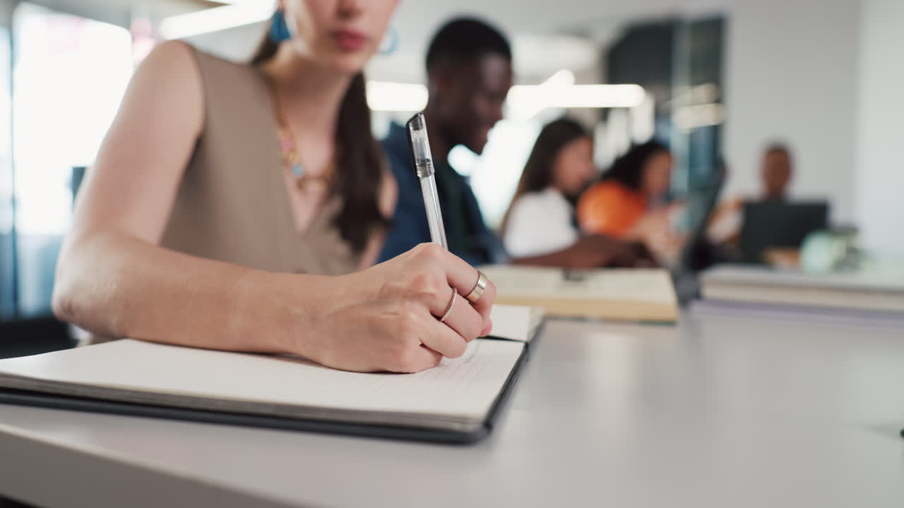 Close Up of Woman's Hand Writing in Notebook During Study Session