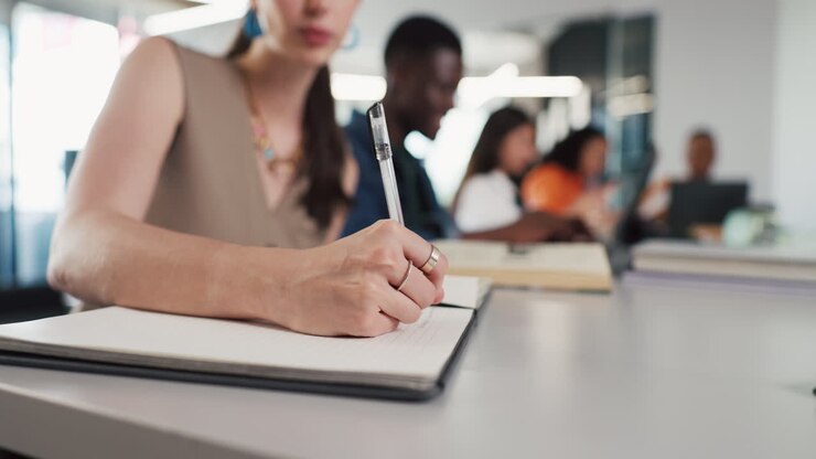 Close Up of Woman's Hand Writing in Notebook During Study Session