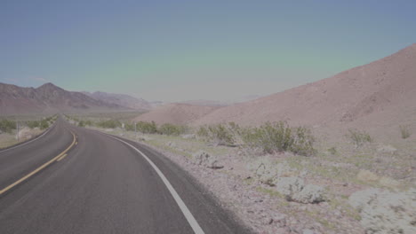 conduciendo a lo largo de un camino del desierto doblar la esquina a cámara lenta