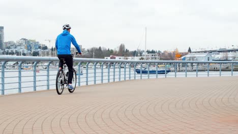 man riding a bike on the promenade near the harbor 4k 4k