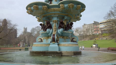 Pan-up-from-the-base-to-the-top-of-Ross-Fountain-in-Princes-Street-gardens-on-a-sunny-day,-Edinburgh,-Scotland