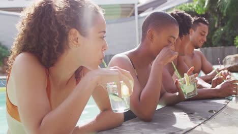 Gruppe-Verschiedener-Männlicher-Und-Weiblicher-Freunde,-Die-Im-Schwimmbad-Lachend-Getränke-Trinken