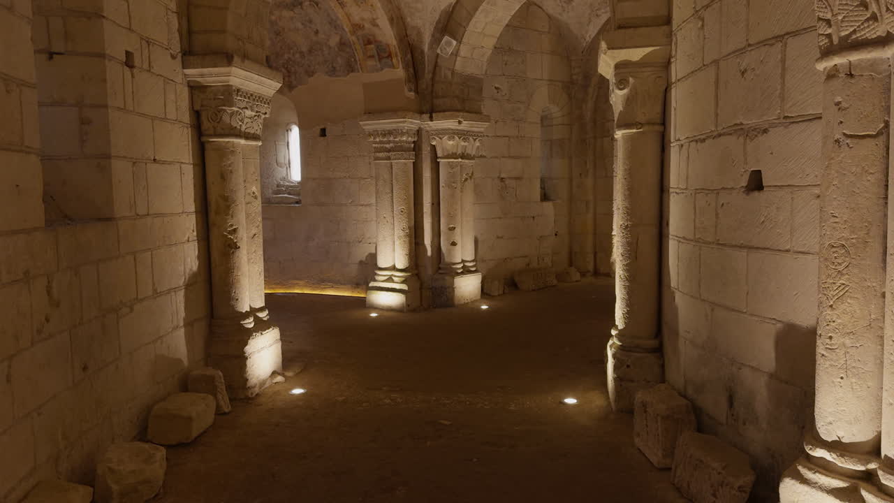 Ancient medieval crypt with stone columns and arches, warm lighting, historic atmosphere
