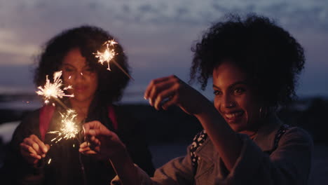 Porträt-Von-Schönen-Gemischtrassigen-Schwestern,-Die-Silvester-Feiern-Und-Wunderkerzen-Halten.-Zwillinge-Tanzen-Am-Strand-Und-Genießen-Die-Abendparty