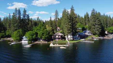 aerial drone view of the settlement near a lake with forest cover