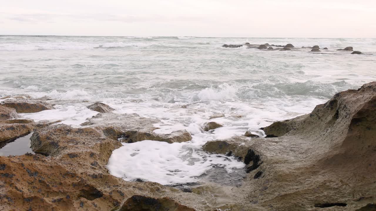 las olas del océano golpean las rocas, creando espuma blanca