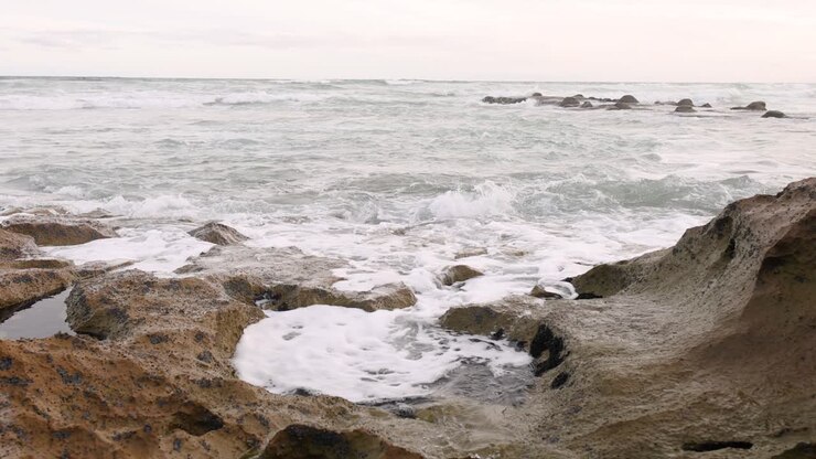 Onde dell'oceano che si infrangono sulle rocce, creando schiuma bianca