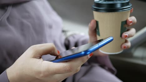 mujeres jóvenes usando teléfonos inteligentes y café mientras están sentadas en un coche