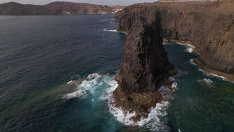 Roque-Partido,-Gran-Canaria:-Fantastic-aerial-view-with-slow-movement-and-in-a-circle-to-the-rock-formation-called-Roque-Partido-on-the-island-of-Gran-Canaria-and-on-a-sunny-day