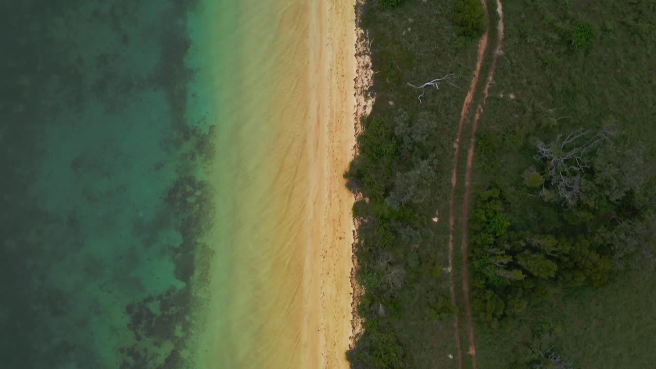 toma de un hermoso centro de playa amarilla en el marco con el océano de un lado y una isla en el otro
