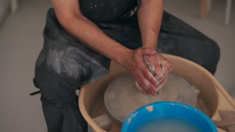 hands working with clay on a pottery wheel