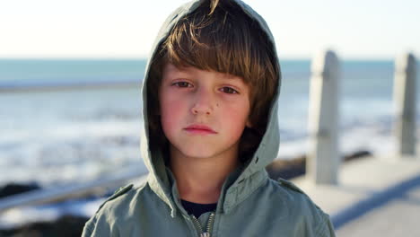 face of sad, lonely and lost boy at beach