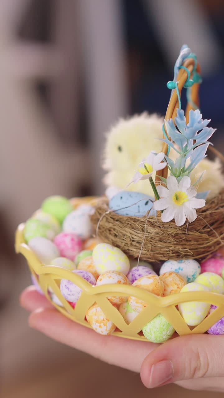 Hands Holding a Festive Easter Basket with Chick and Colorful Eggs