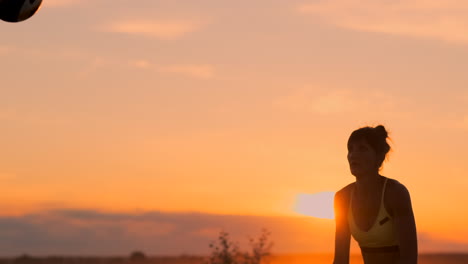 An-Einem-Schönen-Sommerabend-Springt-Ein-Sportliches-Mädchen-Beim-Beachvolleyball-In-Die-Luft-Und-Schlägt-Den-Ball-über-Das-Netz.-Eine-Kaukasische-Frau-Erzielt-Einen-Punkt.