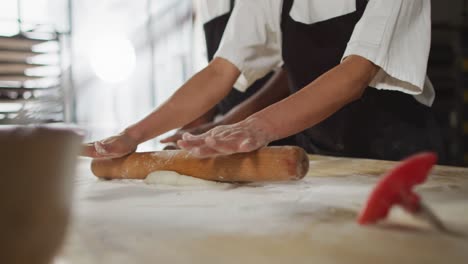 animation of hands of asian female baker rolling sourdough for bread