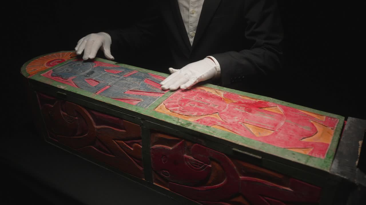 장갑을 입은 사람이 고대 유물을 검사하고 있습니다.