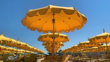 filas de sombrillas de playa abiertas contra el cielo azul claro con espacio para el título