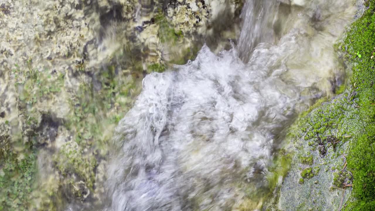 Corso d'acqua che scorre, ruscello nella natura su pietre muschiose