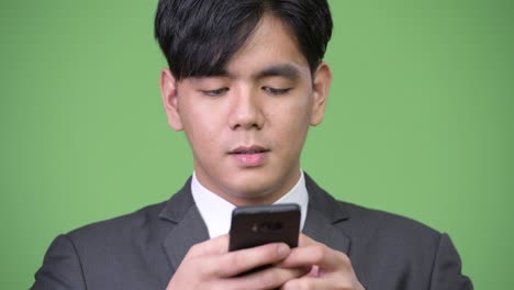 휴대전화를 사용하는 젊은 잘생긴 아시아 사업가