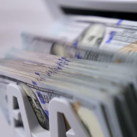 money counting machine. banknote counter are counting hundred dollar bills. close-up