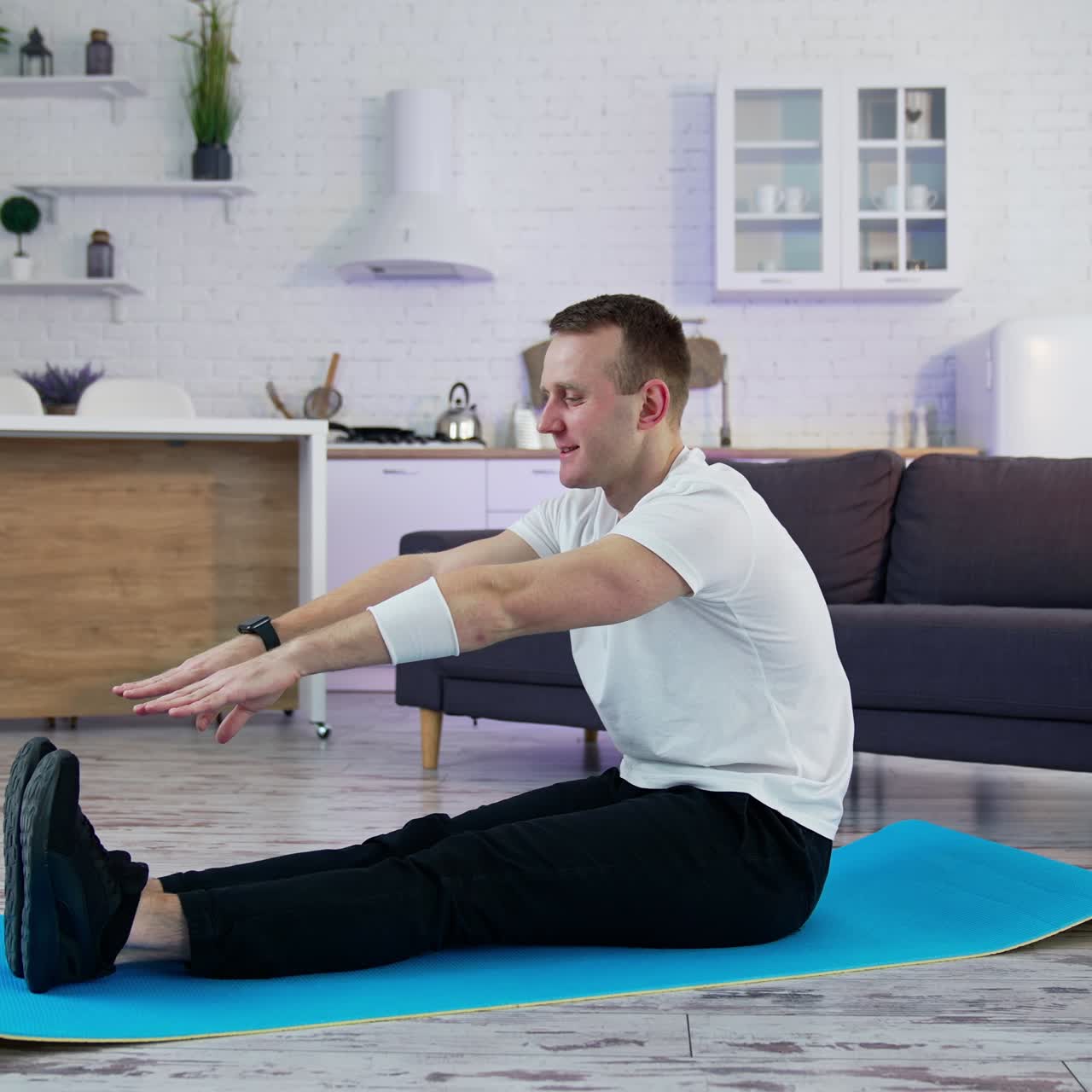 Strong man on quarantine working out in home. Young athletic healthy male training indoors