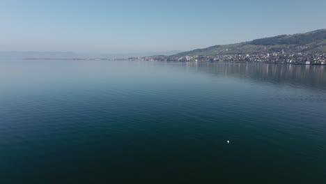 aerial-of-lake-with-hill-and-town-in-background