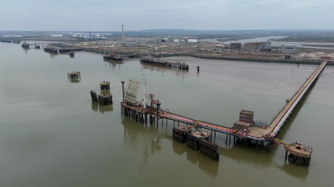 Aerial drone footage showcasing large industrial piers at a gas terminal on Canvey Island, UK, along the River Thames