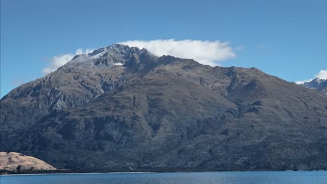 nube suave tocando el pico de la montaña sobre el lago wanaka, nueva zelanda