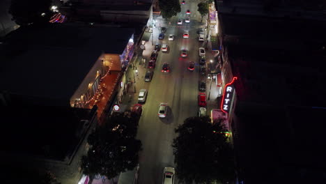 aerial view of a city street at night with cars and people