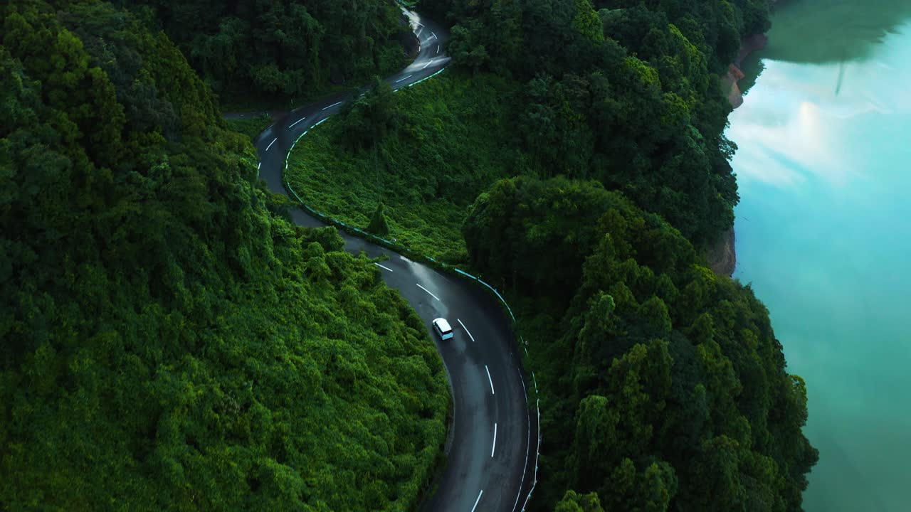 일본 코치 의  ⁇ 은 산길 을 가로질러 운전 하는 자동차 의 4k 항공 사진