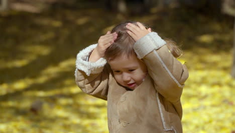 Ginkgo-Biloba-Leaves-Falling-in-Slow-motion-on-Little-Girl-in-Autumn-Park